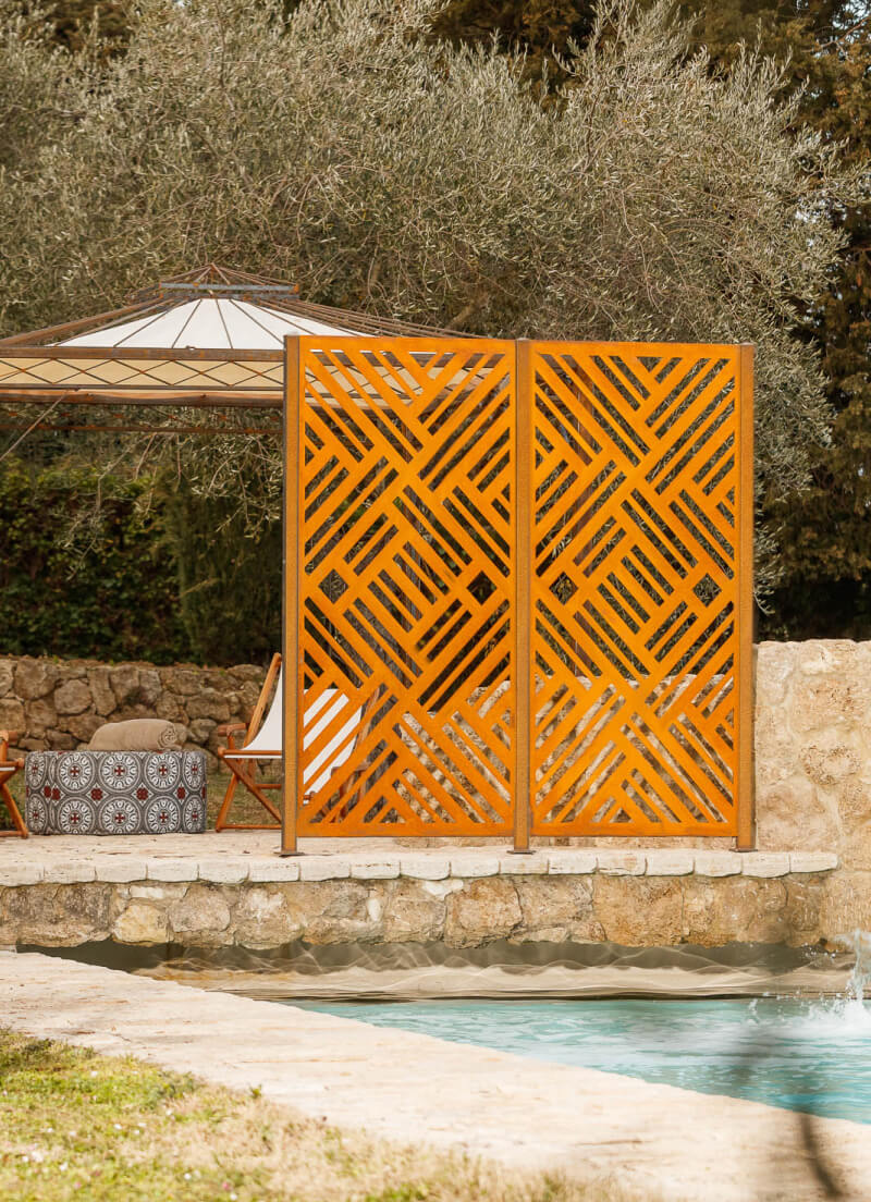 Metallsichtschutz Adda vor einem mediterranen Pool | Cortenstahl
